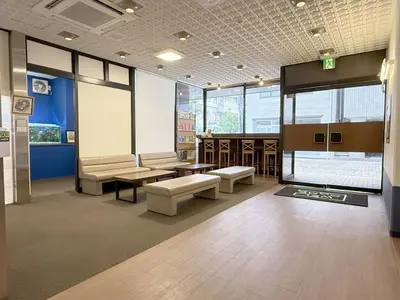 a waiting room with benches and tables in a building at Tokyo Ueno New Izu Hotel in Tokyo