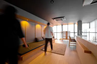 a man is walking in a room with a couch at AET & o3 HOTEL in Tokyo