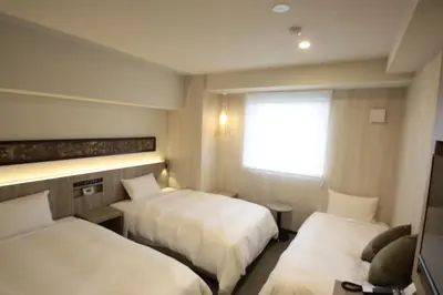 a hotel room with two beds and a window at Hotel Il Fiore Kasai in Tokyo