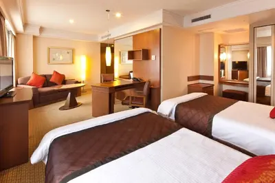 a hotel room with two beds and a couch at Royal Park Hotel in Tokyo