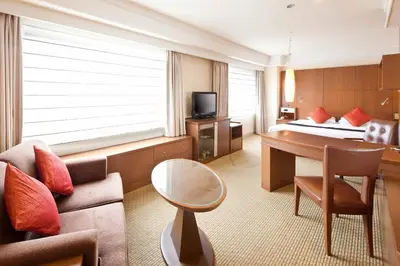 a hotel room with a couch and a bed at Royal Park Hotel in Tokyo