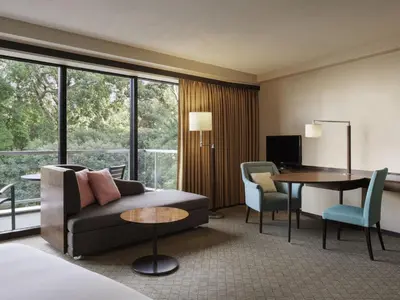 a hotel room with a couch and a table and chairs at Sheraton Miyako Hotel Tokyo in Tokyo