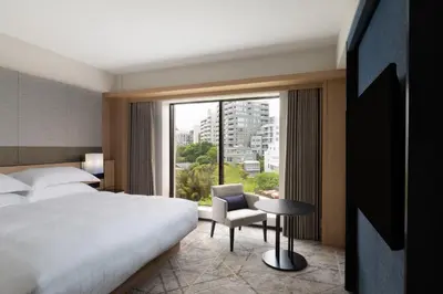 a hotel room with a bed and a chair and a window at Sheraton Miyako Hotel Tokyo in Tokyo