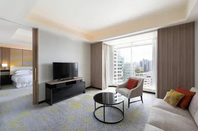 a hotel room with a couch and a tv and a bed at Sheraton Miyako Hotel Tokyo in Tokyo