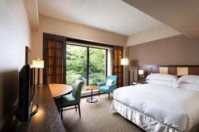a hotel room with a bed and a table and chairs at Sheraton Miyako Hotel Tokyo in Tokyo