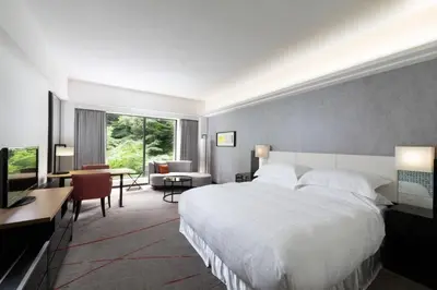 a bedroom with a large white bed and a desk at Sheraton Miyako Hotel Tokyo in Tokyo