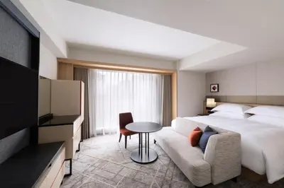 a hotel room with a bed and a couch and a tv at Sheraton Miyako Hotel Tokyo in Tokyo