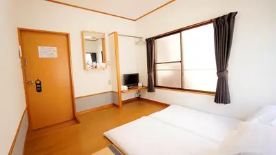 a small room with a bed and a window at House Ikebukuro in Tokyo