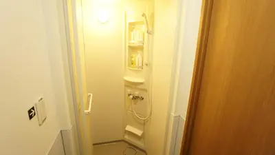 a small bathroom with a shower and a toilet at House Ikebukuro in Tokyo