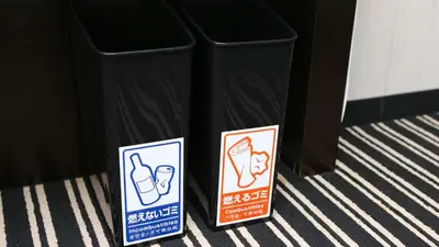 a couple of signs next to a trash can at APA Hotel TKP Tokyo Nishi-Kasai in Tokyo