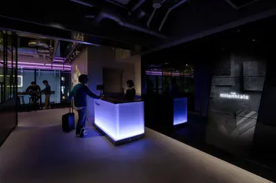 a man standing at a counter in an office with a suitcase at The Millennials Shibuya in Tokyo