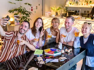 a group of people sitting around a table with drinks at The Millennials Shibuya in Tokyo