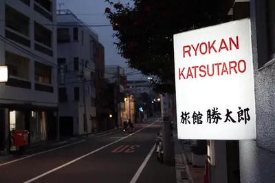 a sign on the side of a building that reads kishiota at Ryokan Katsutaro in Tokyo