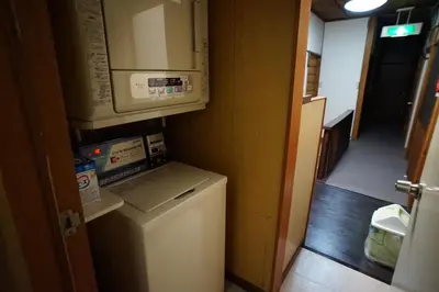 a small kitchen with a washing machine and a microwave at Ryokan Katsutaro in Tokyo