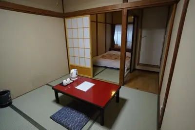 a small room with a red table and a mirror at Ryokan Katsutaro in Tokyo