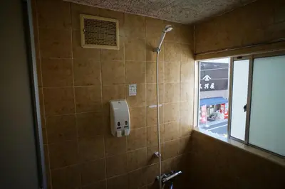 a bathroom with a shower stall with a window at Ryokan Katsutaro in Tokyo