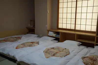 two beds in a room with white sheets at Annex Katsutaro Ryokan in Tokyo