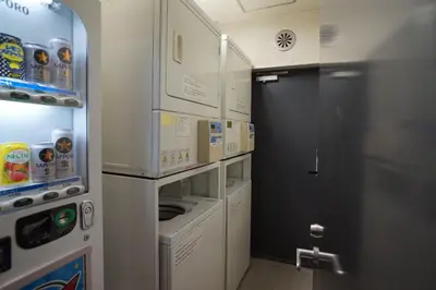 a small kitchen with a washer and dryer at Annex Katsutaro Ryokan in Tokyo