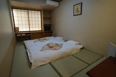 a room with a bed with sheets on it at Annex Katsutaro Ryokan in Tokyo