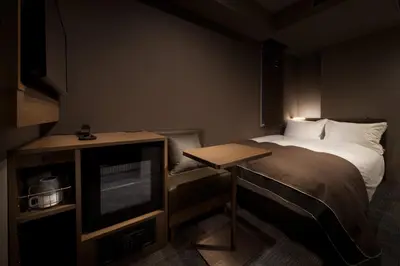 a small room with a bed and a television at Nest Hotel Tokyo Hanzomon in Tokyo