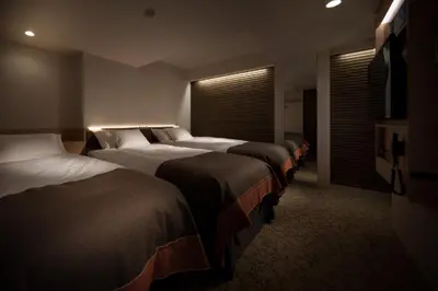 a row of beds in a hotel room at Nest Hotel Tokyo Hanzomon in Tokyo