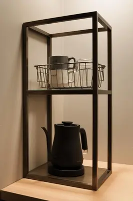 a black tea kettle and a basket on a shelf at Nest Hotel Tokyo Hanzomon in Tokyo