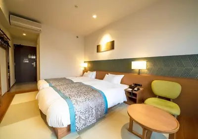 a hotel room with a bed and a table and chair at Ours Inn Hankyu in Tokyo