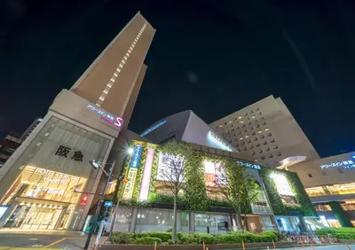 a large building with lights in front of it at night at Ours Inn Hankyu in Tokyo