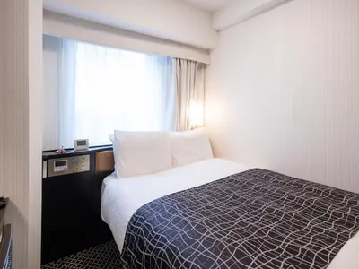 a hotel room with a bed and a window at APA Hotel Kanda Ekimae in Tokyo