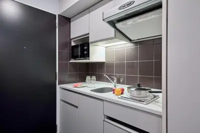 a kitchen with a sink and a microwave at Citadines Shinjuku Tokyo in Tokyo