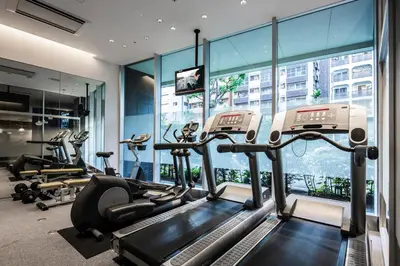 a gym with treadmills and ellipticals in a building at Citadines Shinjuku Tokyo in Tokyo