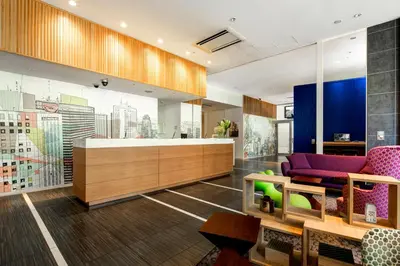 a living room with a purple couch and a table at Citadines Shinjuku Tokyo in Tokyo
