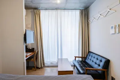 a living room with a couch and a table at bmj Shinjuku Okubo in Tokyo