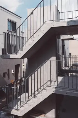 a metal staircase in front of a building at bmj Shinjuku Okubo in Tokyo
