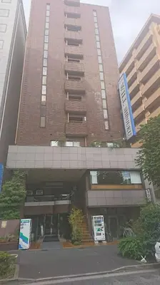 a tall building with a parking garage in front of it at Residence Hotel Will Shinjuku in Tokyo