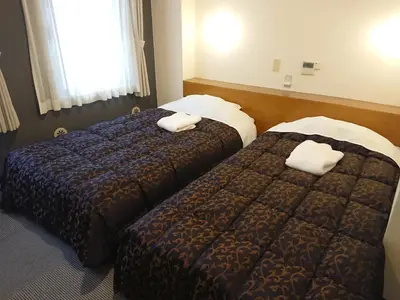two beds in a hotel room with towels on them at Residence Hotel Will Shinjuku in Tokyo