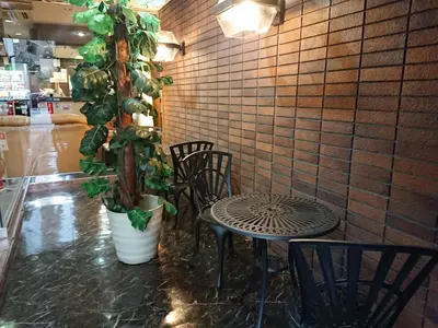 a table and chairs in a room with a plant at Residence Hotel Will Shinjuku in Tokyo