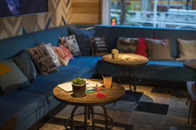 a blue couch and two tables in a room at MOXY Tokyo Kinshicho in Tokyo