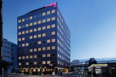 a tall building with a sign on top of it at MOXY Tokyo Kinshicho in Tokyo