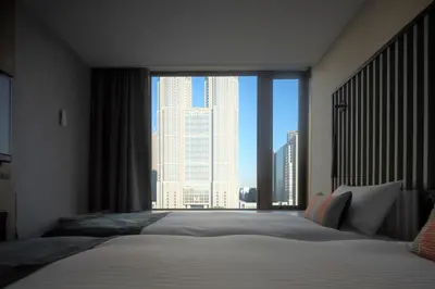 a bedroom with a bed with a large window at THE KNOT TOKYO Shinjuku in Tokyo