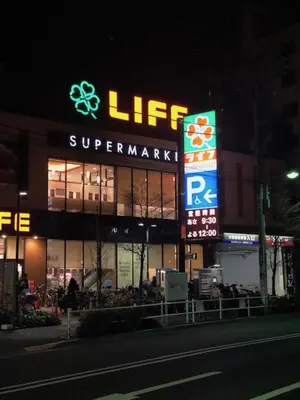 a store with a lit up sign at night at Shinjuku Apartments 101 in Tokyo