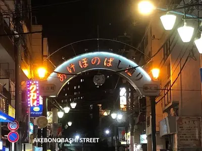 a lit up sign over a street at night at Shinjuku Apartments 101 in Tokyo