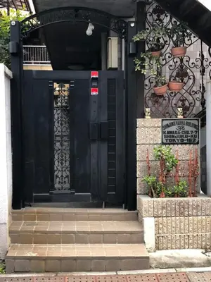 a black front door of a house with plants at Shinjuku Apartments 101 in Tokyo