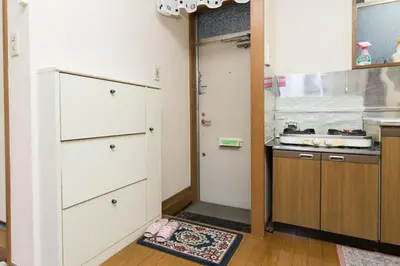 a kitchen with a door leading into a kitchen with a counter at Shinjuku Apartment 103 in Tokyo