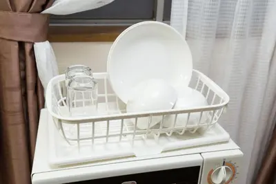 a dish drying rack on top of a microwave at Shinjuku Apartment 103 in Tokyo