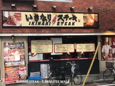 a restaurant with signs on the front of a building at Shinjuku Apartment 102 in Tokyo