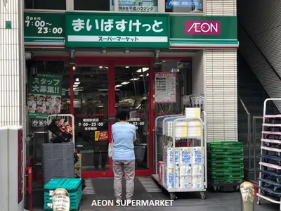 a man is standing outside of a store at Shinjuku Apartment 102 in Tokyo