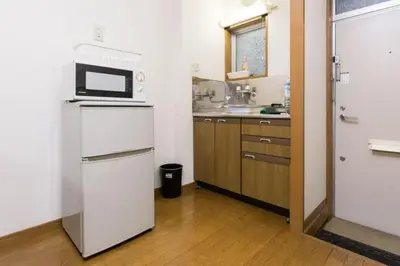 a kitchen with a white refrigerator and a microwave at Shinjuku Apartment 102 in Tokyo