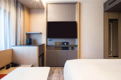 a room with two beds and a flat screen tv at Hotel Metropolitan Edmont Tokyo in Tokyo