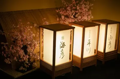 three lanterns with writing on them next to flowers at Hotel Metropolitan Edmont Tokyo in Tokyo